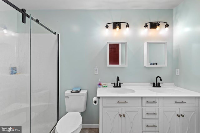 bathroom featuring vanity, a shower with door, and toilet