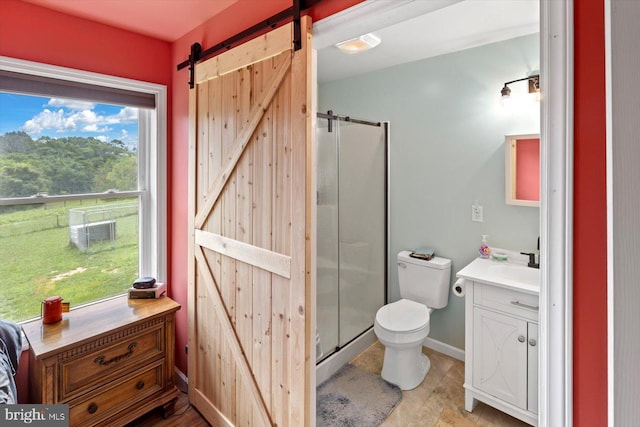 bathroom with a shower with door, vanity, and toilet