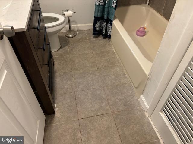 bathroom featuring tile patterned flooring, vanity, a tub, and toilet