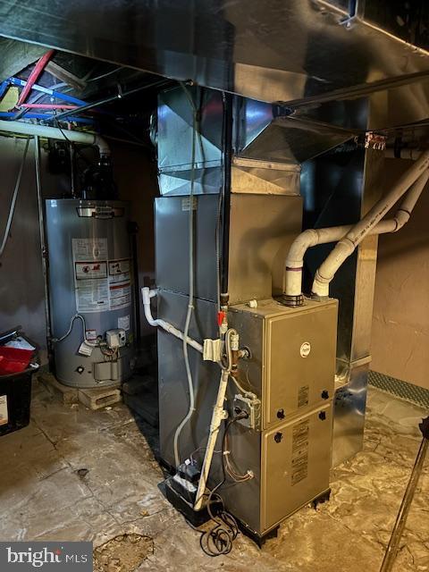 utility room with heating unit and water heater