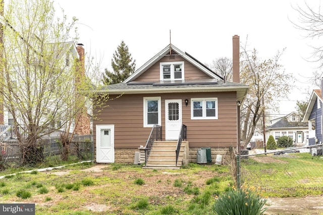 back of house featuring a yard and central air condition unit