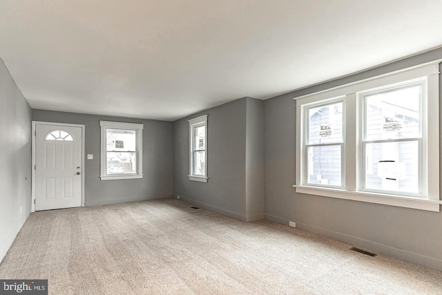 foyer entrance featuring light colored carpet