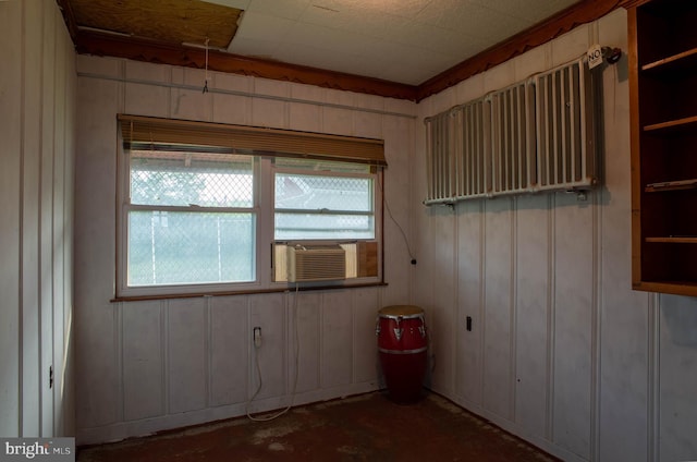 empty room with cooling unit, crown molding, and concrete flooring