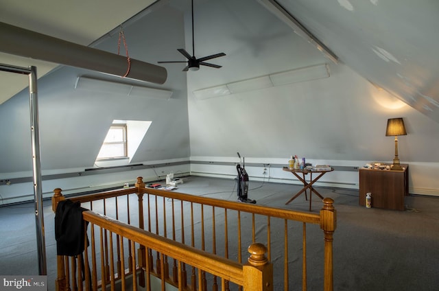 interior space featuring lofted ceiling with skylight, ceiling fan, and carpet flooring