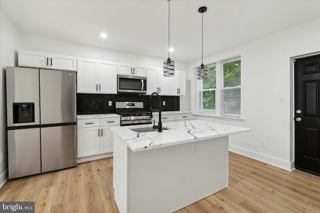 kitchen featuring white cabinetry, appliances with stainless steel finishes, and a center island with sink