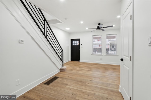 foyer entrance with ceiling fan and light hardwood / wood-style flooring