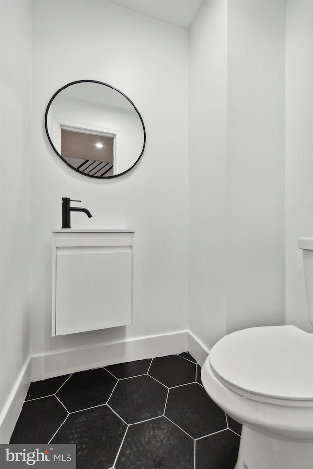 bathroom with tile patterned flooring, vanity, and toilet