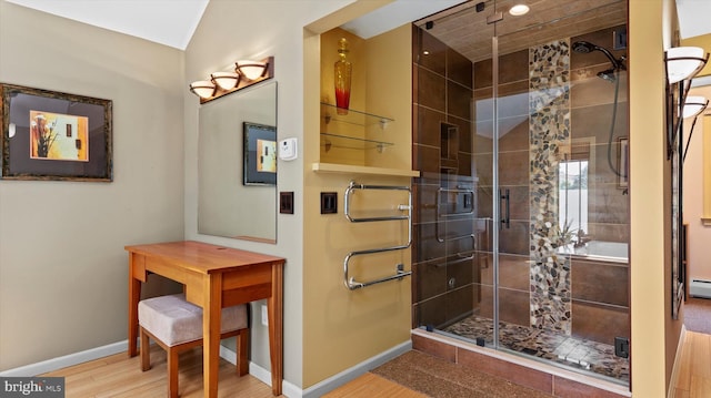 bathroom with a baseboard radiator, wood-type flooring, and a shower with shower door