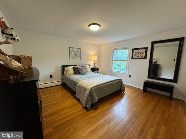 bedroom featuring hardwood / wood-style floors and a baseboard radiator