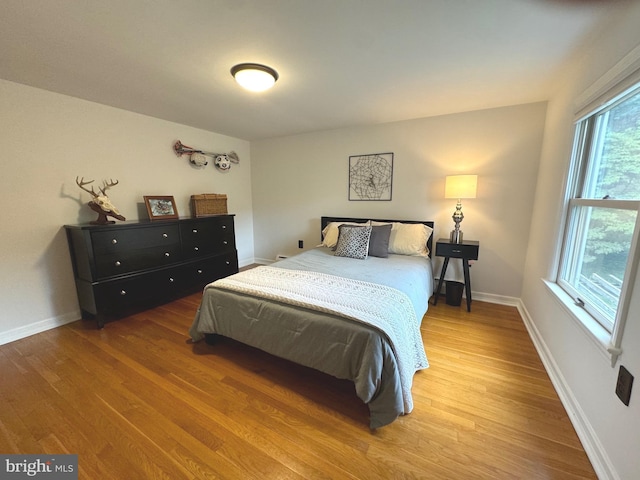 bedroom featuring multiple windows and hardwood / wood-style floors