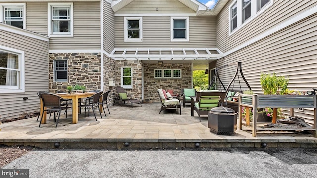 view of patio with an outdoor living space with a fire pit