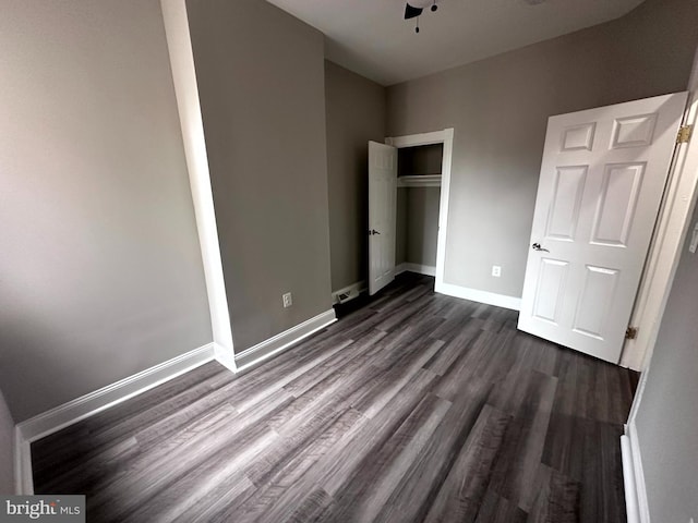 unfurnished bedroom featuring a closet, ceiling fan, and dark hardwood / wood-style floors