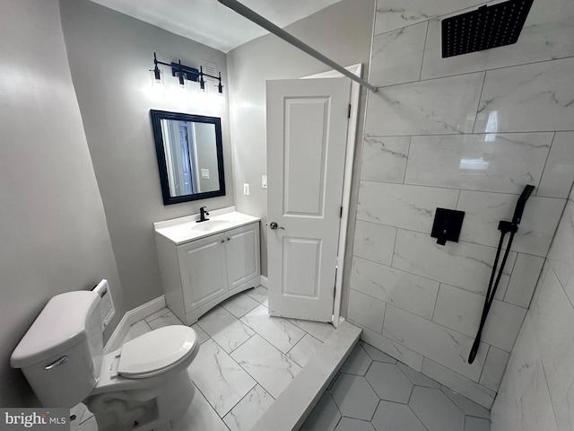 bathroom featuring tile patterned floors, vanity, a tile shower, and toilet