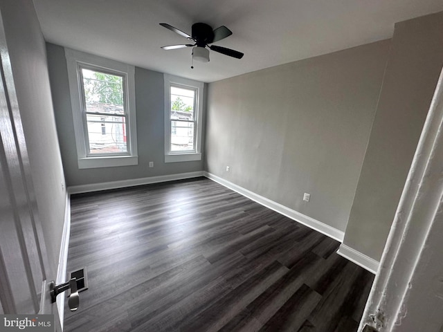 empty room featuring dark hardwood / wood-style flooring and ceiling fan