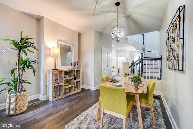 dining area featuring dark wood-type flooring and a notable chandelier