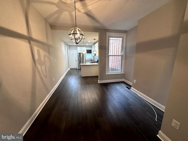 unfurnished dining area with dark hardwood / wood-style floors and a chandelier