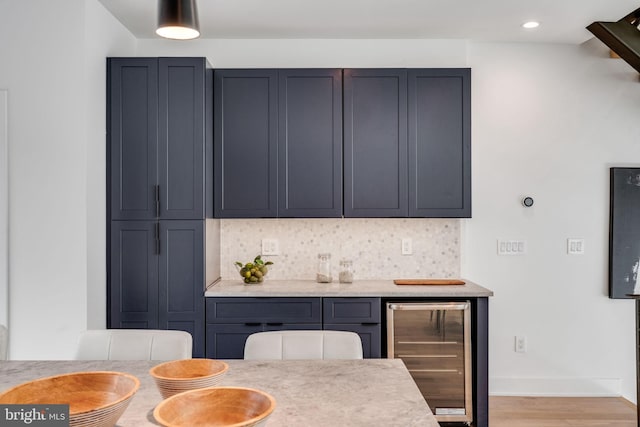 kitchen with hardwood / wood-style flooring, beverage cooler, and decorative backsplash