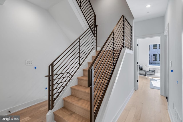 staircase with hardwood / wood-style flooring