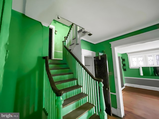 stairs featuring hardwood / wood-style floors