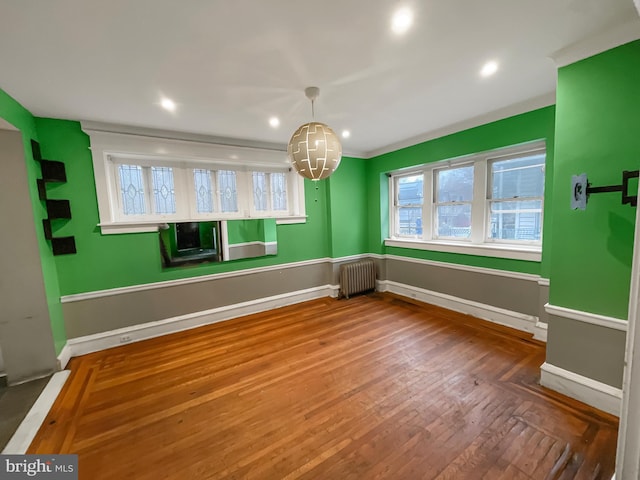 unfurnished dining area featuring radiator and hardwood / wood-style floors