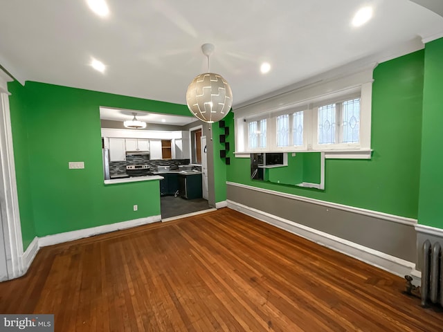 kitchen featuring dark hardwood / wood-style floors, white cabinets, decorative backsplash, hanging light fixtures, and stainless steel appliances