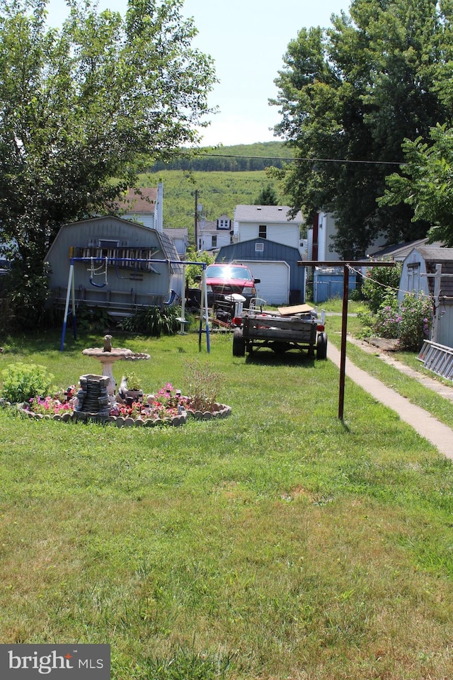 exterior space featuring an outdoor structure, a garage, and a front yard