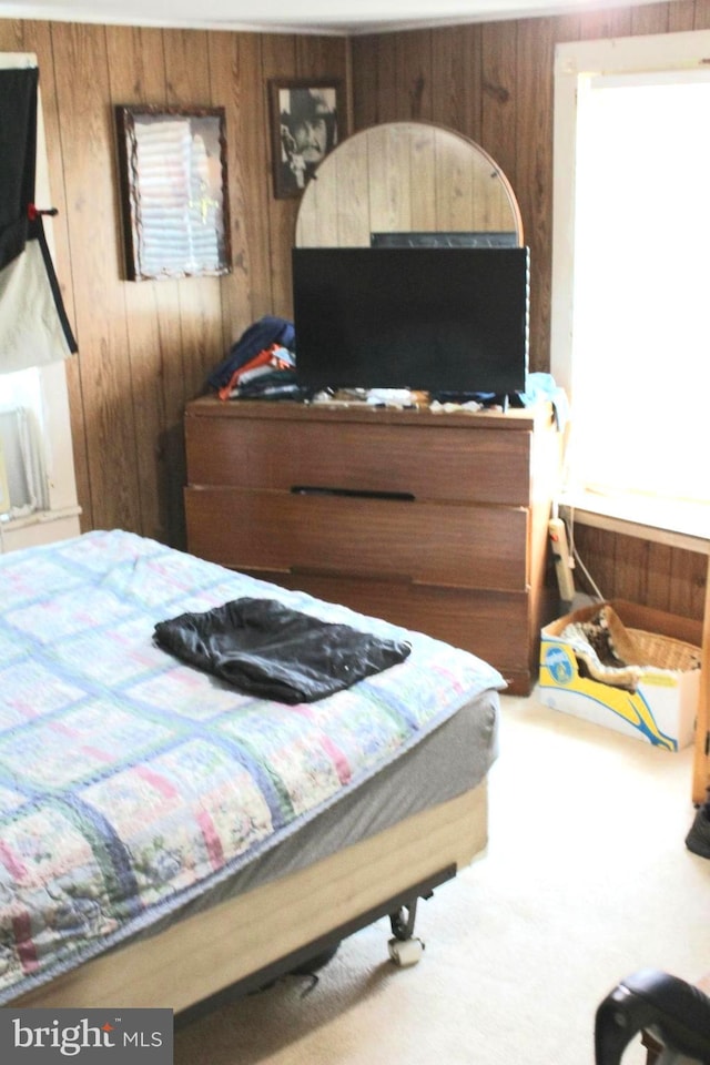 bedroom with carpet floors and wooden walls