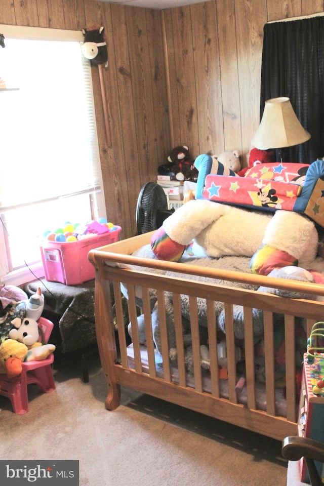 bedroom featuring wooden walls and carpet flooring