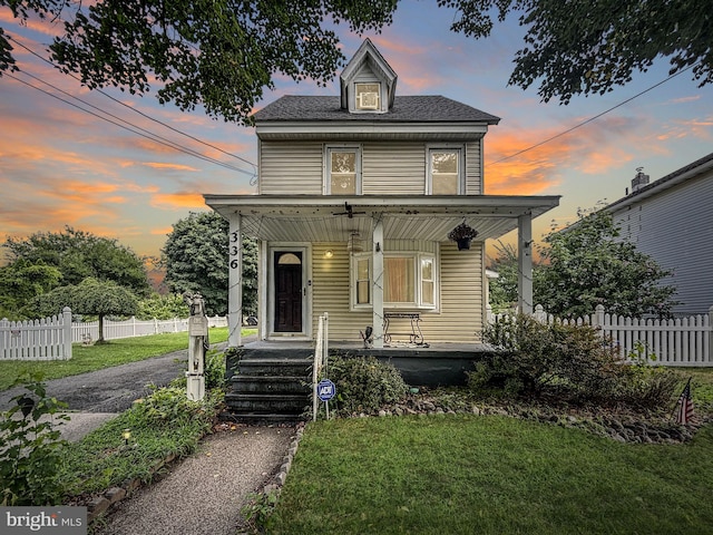 view of front of property featuring a yard and covered porch