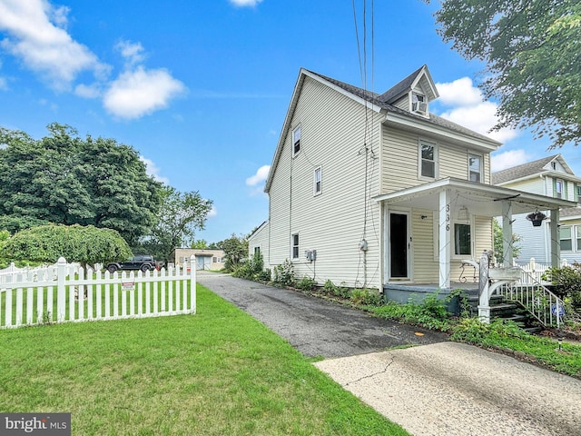 view of property exterior with a yard and covered porch