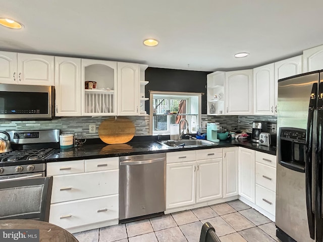 kitchen featuring light tile patterned flooring, appliances with stainless steel finishes, sink, and white cabinets