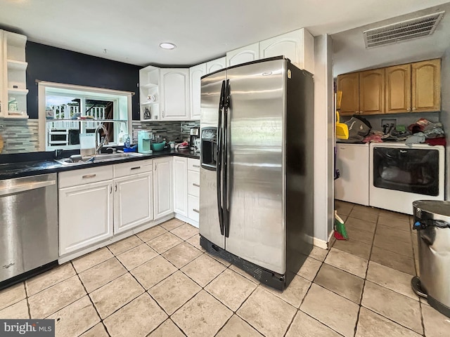 kitchen featuring light tile patterned floors, sink, stainless steel appliances, white cabinets, and separate washer and dryer