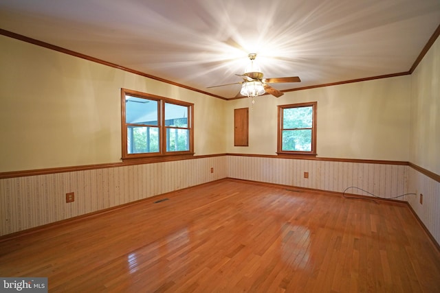 spare room featuring hardwood / wood-style flooring, ceiling fan, and ornamental molding