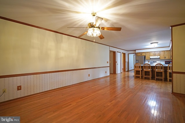 unfurnished living room featuring ceiling fan, light hardwood / wood-style flooring, and crown molding