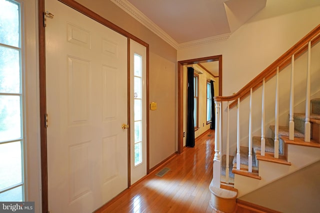 foyer entrance with hardwood / wood-style floors and ornamental molding