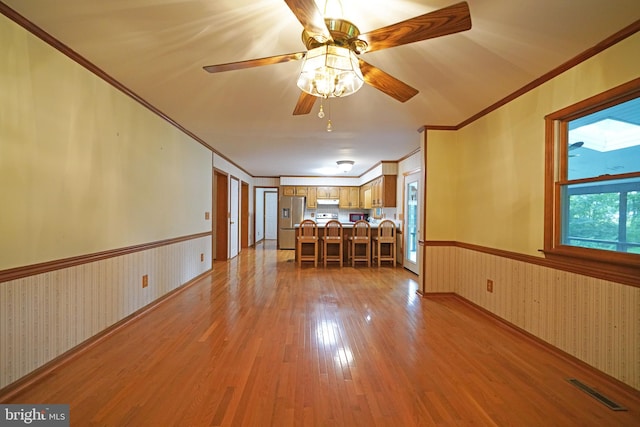 interior space with ceiling fan, light wood-type flooring, and crown molding