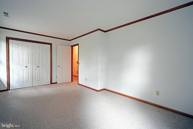 unfurnished bedroom with a closet and crown molding