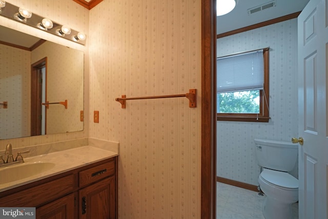 bathroom featuring vanity, toilet, and crown molding