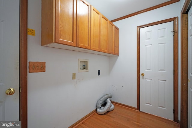 washroom with ornamental molding, hookup for a washing machine, cabinets, light hardwood / wood-style floors, and electric dryer hookup