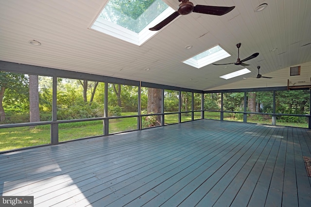 unfurnished sunroom with a healthy amount of sunlight, ceiling fan, and vaulted ceiling with skylight