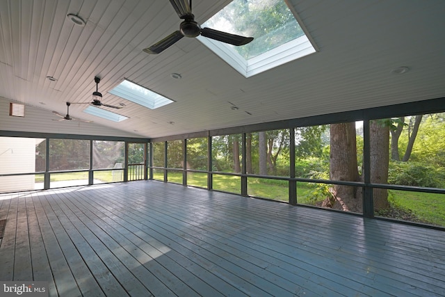 unfurnished sunroom featuring a healthy amount of sunlight, ceiling fan, vaulted ceiling with skylight, and wooden ceiling