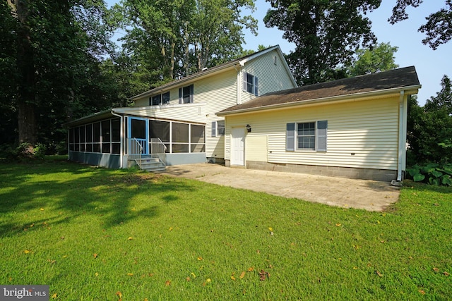 rear view of property featuring a patio, a sunroom, and a yard