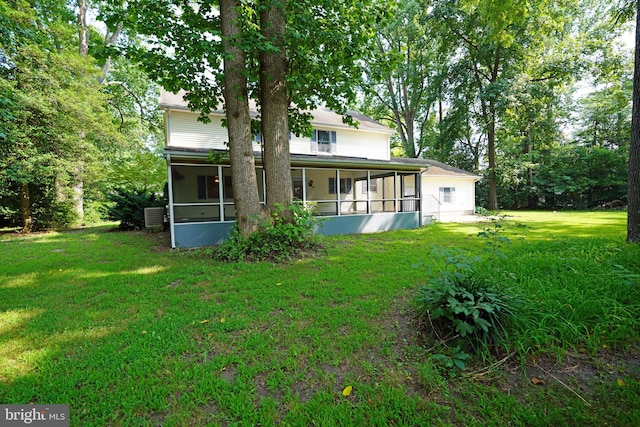 rear view of house with a sunroom and a yard