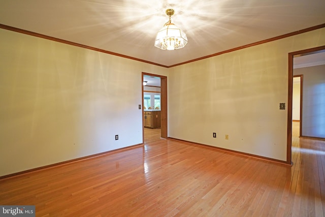 unfurnished room with light hardwood / wood-style flooring, crown molding, and a notable chandelier