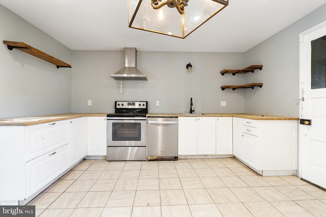 kitchen with sink, white cabinetry, stainless steel appliances, kitchen peninsula, and wall chimney exhaust hood