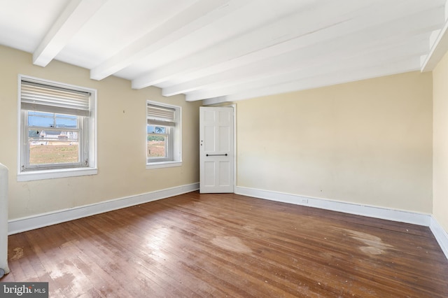 unfurnished room with beamed ceiling and hardwood / wood-style floors