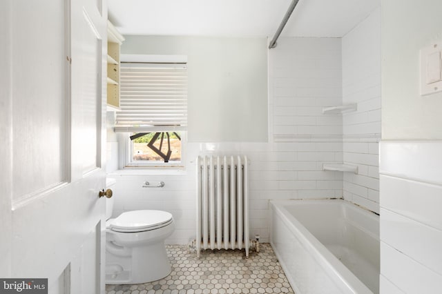 bathroom featuring a bathing tub, radiator heating unit, tile walls, toilet, and tile patterned floors