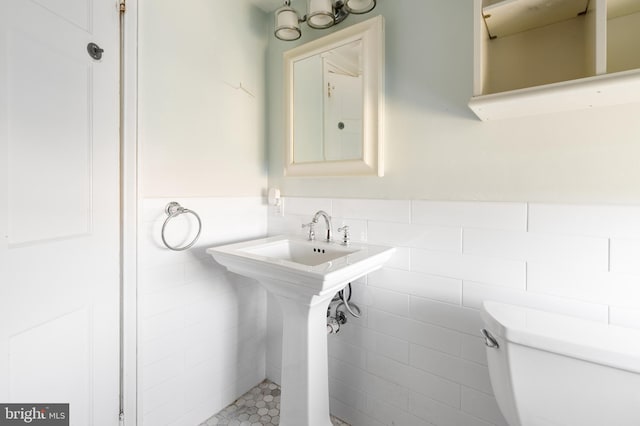 bathroom with tile walls and toilet