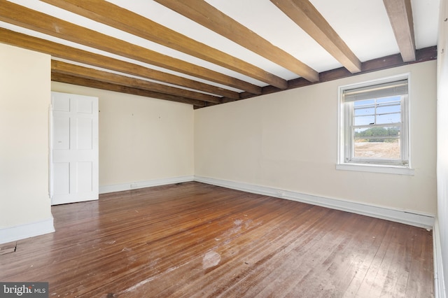 unfurnished room with beam ceiling and dark wood-type flooring