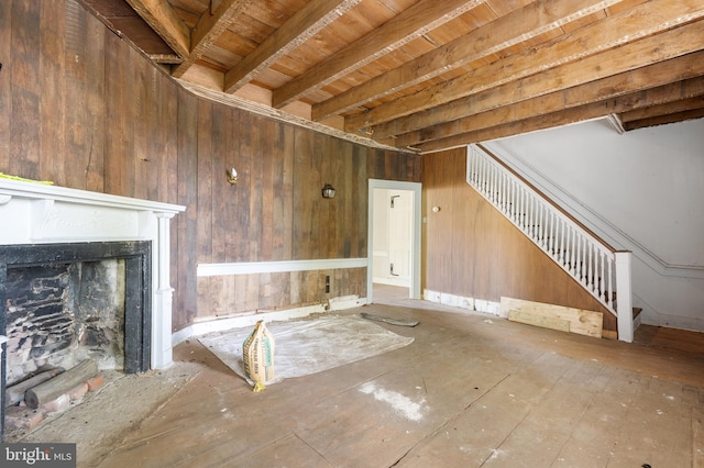 unfurnished living room featuring wood ceiling and wood walls